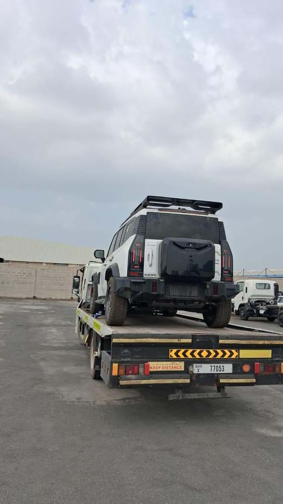 Black SUV loaded onto a recovery flatbed in Dubai