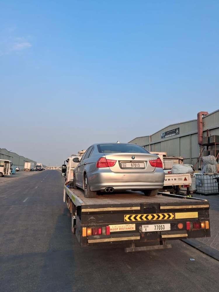Silver BMW sedan secured on a recovery flatbed in Dubai